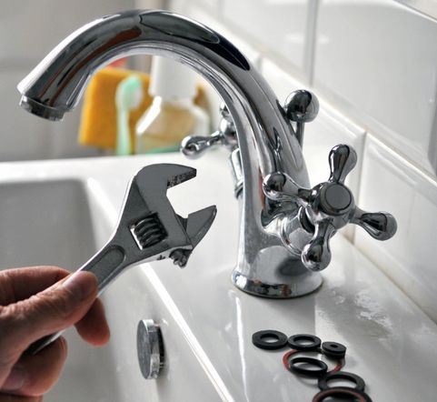 hand holding a wrench for fixing leaking faucet murfreesboro tn